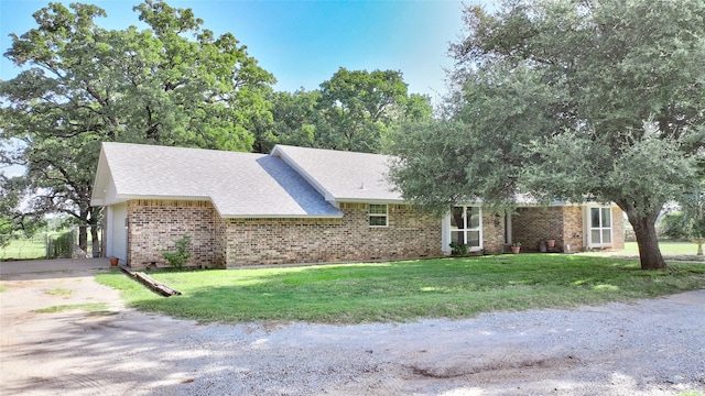 ranch-style home with a front lawn and a garage