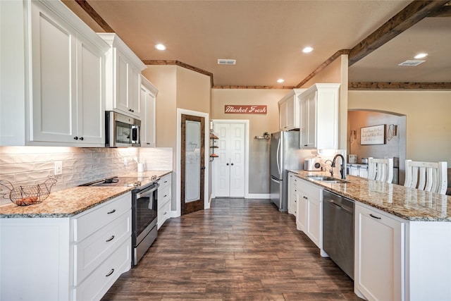 kitchen featuring light stone counters, white cabinets, appliances with stainless steel finishes, and sink