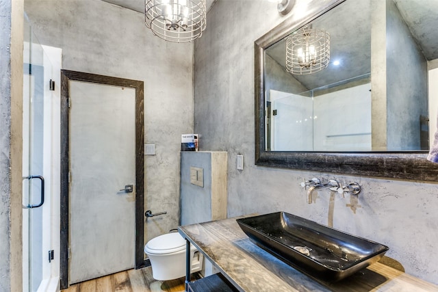 bathroom featuring sink, a shower with shower door, a chandelier, and wood-type flooring