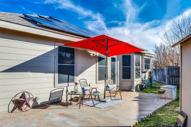 rear view of house with solar panels and a patio area