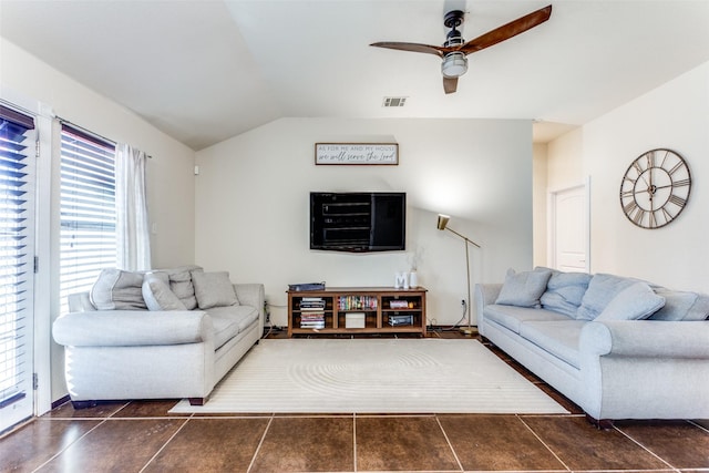 living room with dark tile patterned flooring, ceiling fan, and vaulted ceiling