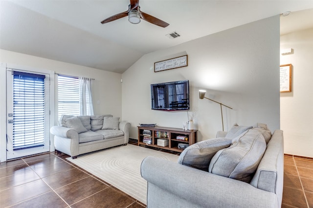 tiled living room with ceiling fan and lofted ceiling