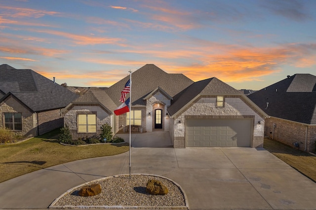 french provincial home with a garage and a lawn