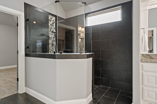 bathroom with vanity, tile patterned flooring, and a tile shower