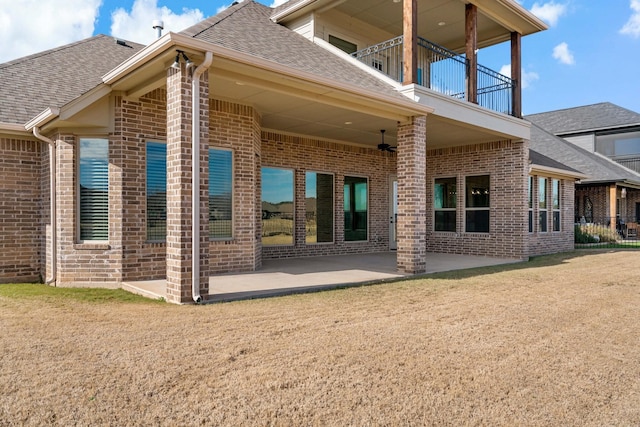 back of property featuring a patio, a balcony, and a yard