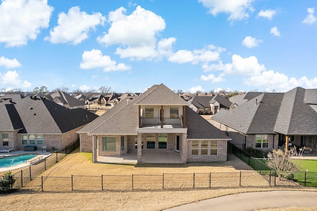 rear view of house with a patio, a balcony, and a lawn