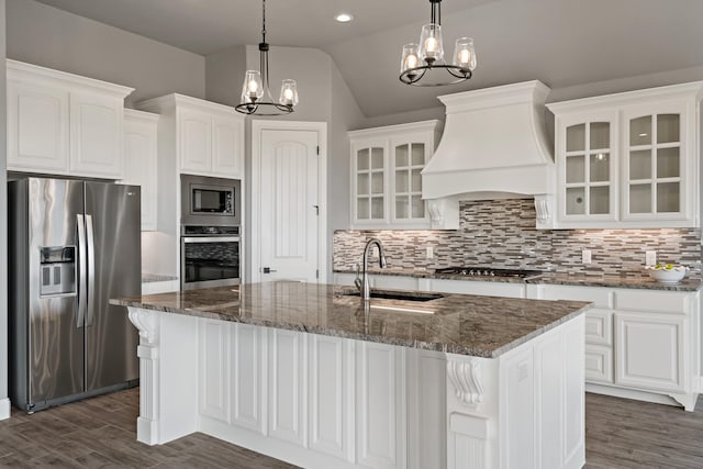 kitchen featuring an inviting chandelier, stainless steel appliances, custom range hood, and white cabinets