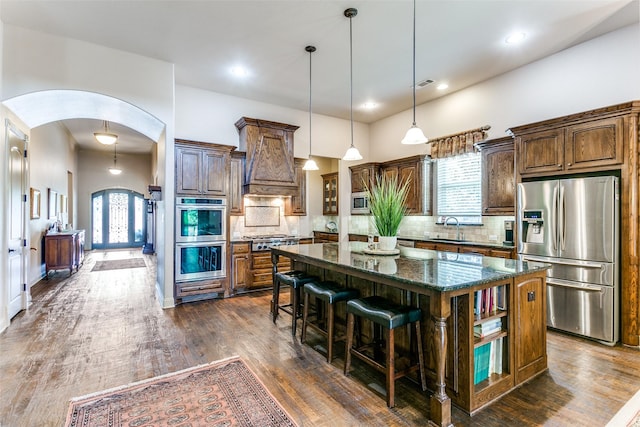 kitchen with sink, stainless steel appliances, a center island, and tasteful backsplash