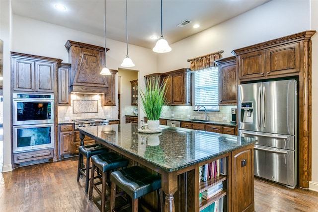 kitchen featuring sink, a kitchen island, tasteful backsplash, and appliances with stainless steel finishes