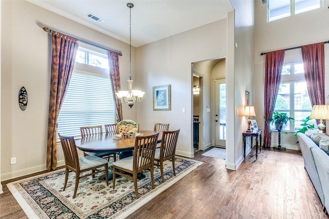 dining room with dark hardwood / wood-style flooring and a chandelier