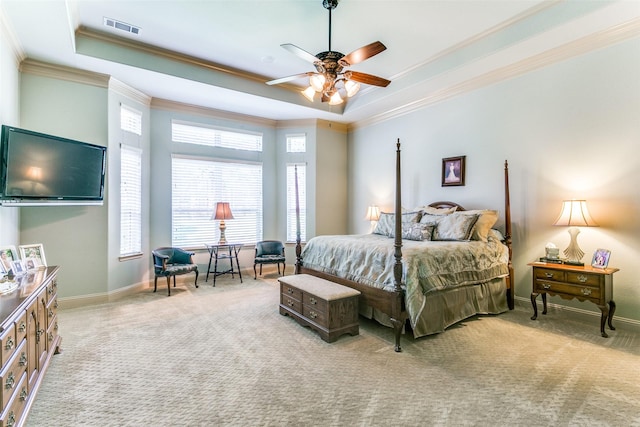 carpeted bedroom featuring ceiling fan, a tray ceiling, and crown molding