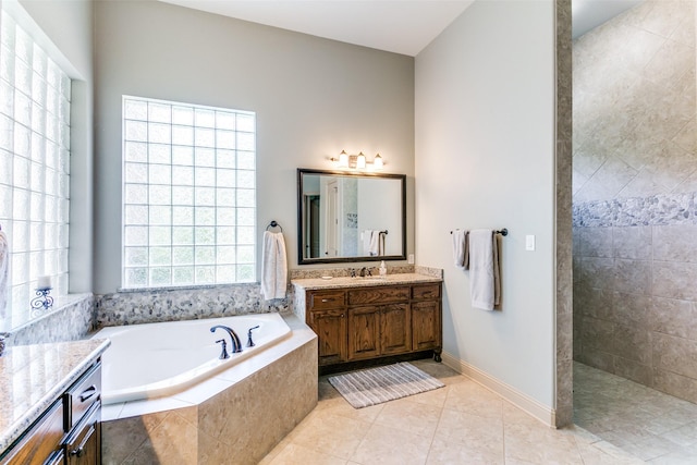 bathroom with vanity, tile patterned floors, and tiled bath