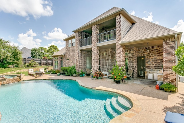 view of pool featuring an outdoor kitchen, a patio area, ceiling fan, and an in ground hot tub