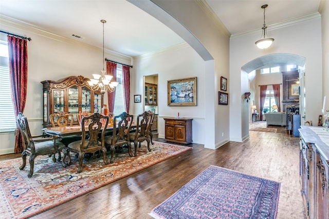 dining room featuring a chandelier, crown molding, and dark wood-type flooring