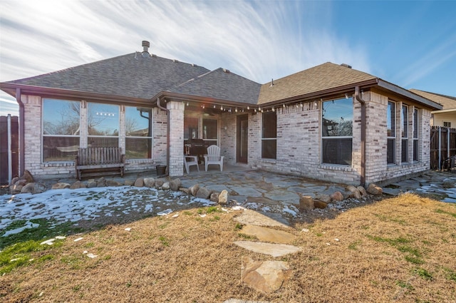 back of house with a patio and a lawn