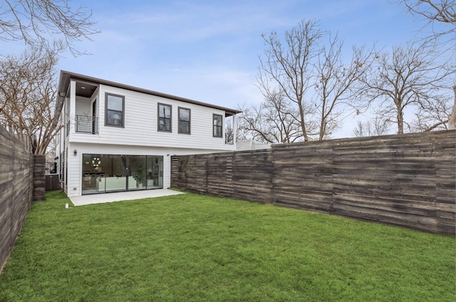 back of property featuring a balcony and a yard