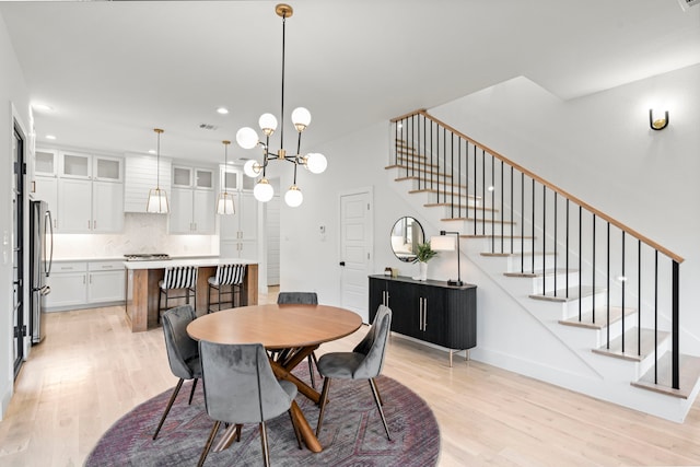 dining room featuring a notable chandelier and light hardwood / wood-style flooring