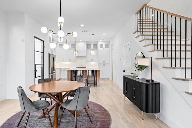 dining room featuring an inviting chandelier and light hardwood / wood-style flooring