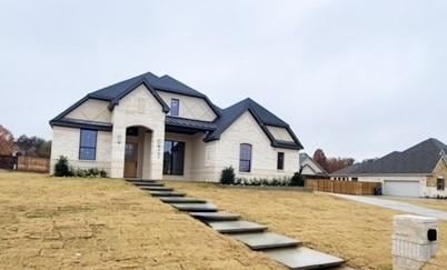 french country home with a front yard and a garage