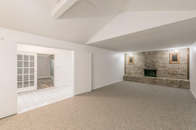 interior space featuring lofted ceiling, french doors, a brick fireplace, and light carpet