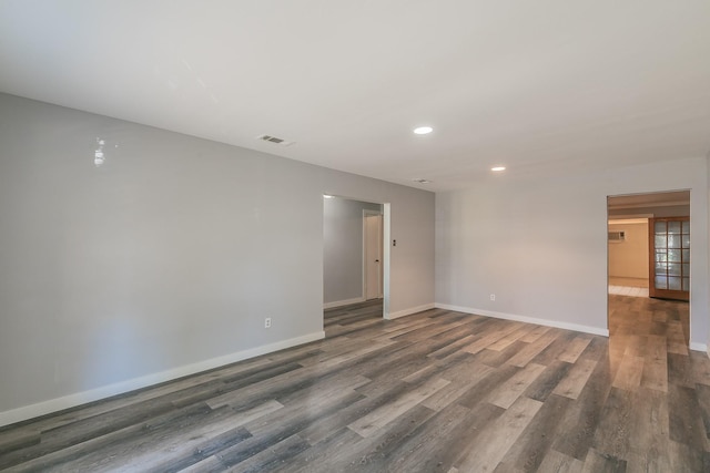 empty room with dark hardwood / wood-style flooring and french doors