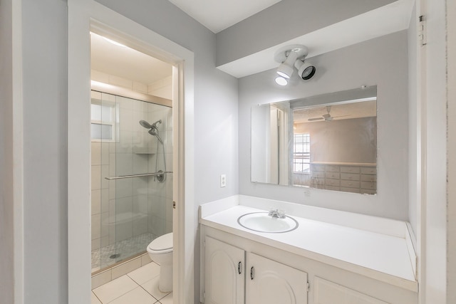 bathroom with toilet, walk in shower, tile patterned floors, ceiling fan, and vanity