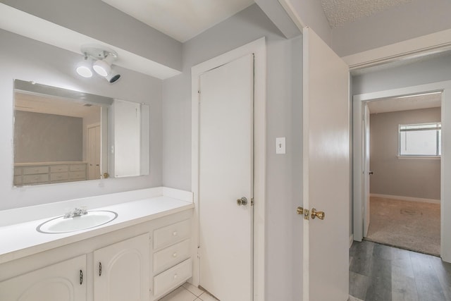 bathroom featuring a textured ceiling, vanity, and hardwood / wood-style flooring