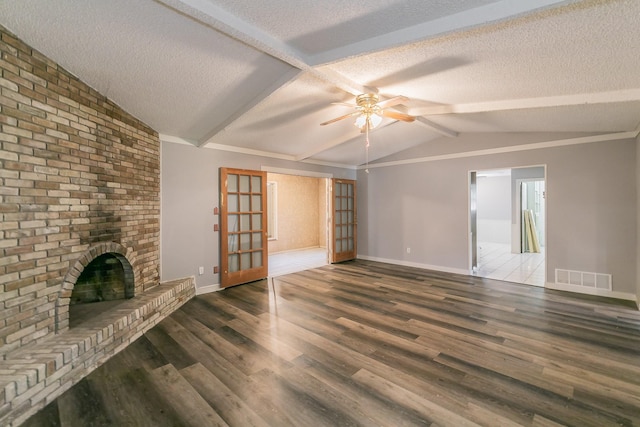 unfurnished living room with a fireplace, a textured ceiling, dark hardwood / wood-style flooring, and vaulted ceiling with beams