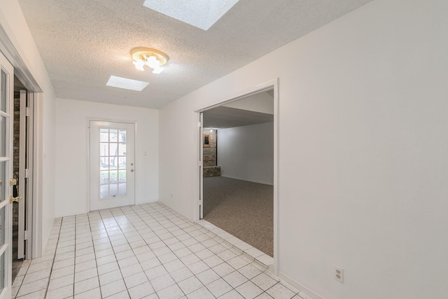 interior space with a textured ceiling and a skylight