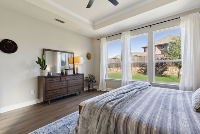 bedroom with a raised ceiling, ceiling fan, ornamental molding, and dark hardwood / wood-style floors