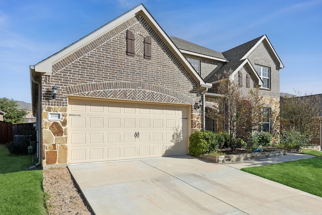 view of front of home with stone siding, an attached garage, driveway, and a front yard