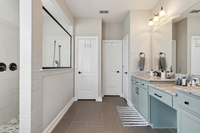 bathroom featuring tile patterned flooring, a shower, and vanity