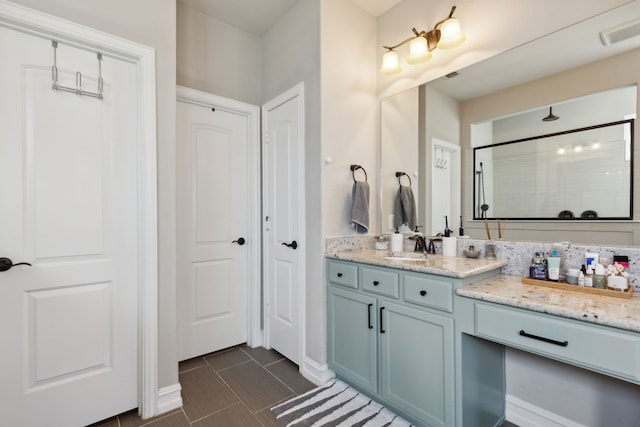 bathroom featuring vanity, tile patterned flooring, and a shower