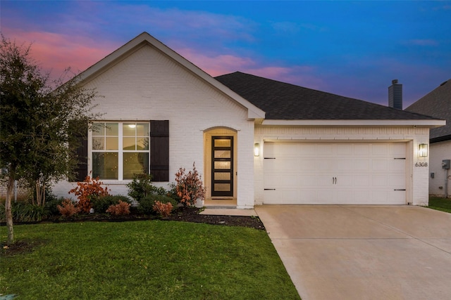 ranch-style house with a garage and a yard