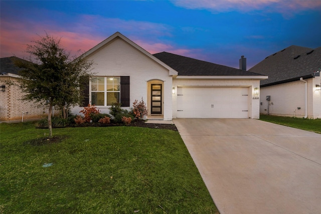 single story home with a garage and a yard