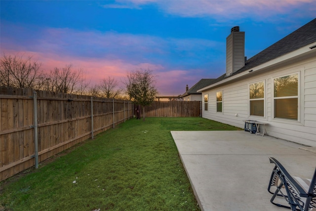 yard at dusk featuring a patio area