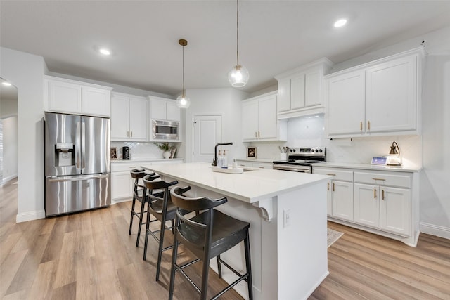 kitchen with white cabinetry, stainless steel appliances, and hanging light fixtures