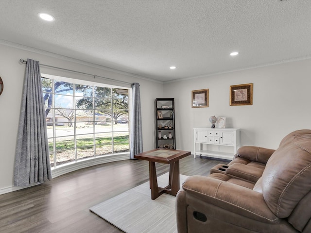 living room with a textured ceiling, ornamental molding, and hardwood / wood-style flooring