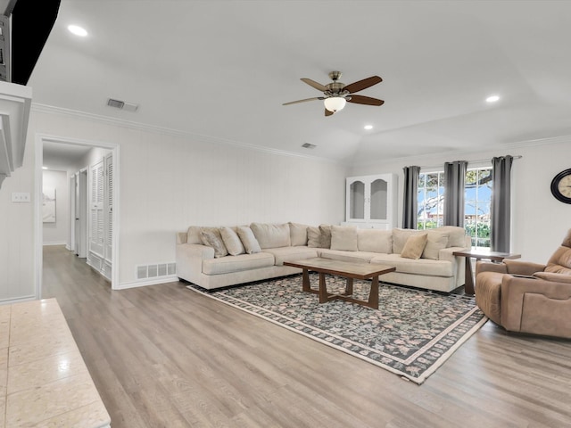 living room with light wood-type flooring, ceiling fan, and crown molding