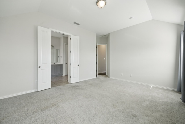 unfurnished bedroom with lofted ceiling and light carpet