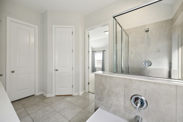 bathroom with a tile shower and tile patterned floors