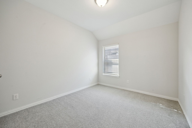 empty room with vaulted ceiling and carpet