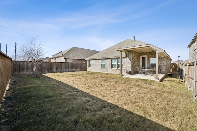 rear view of house featuring a patio and a lawn