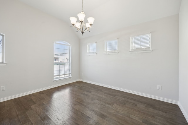 unfurnished room featuring dark hardwood / wood-style floors, lofted ceiling, and a chandelier