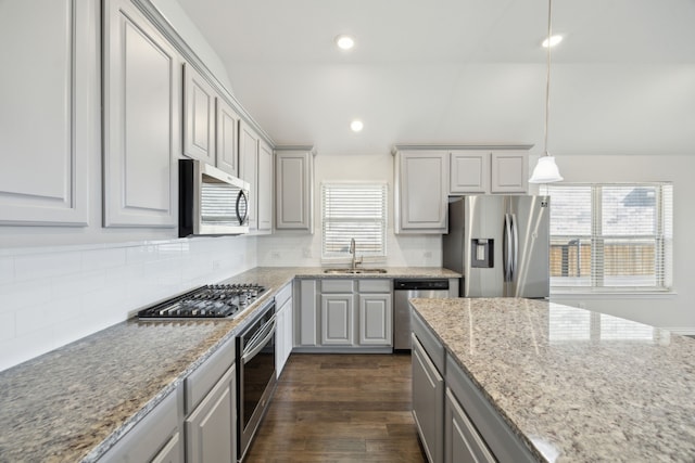 kitchen featuring sink, decorative backsplash, pendant lighting, gray cabinetry, and appliances with stainless steel finishes