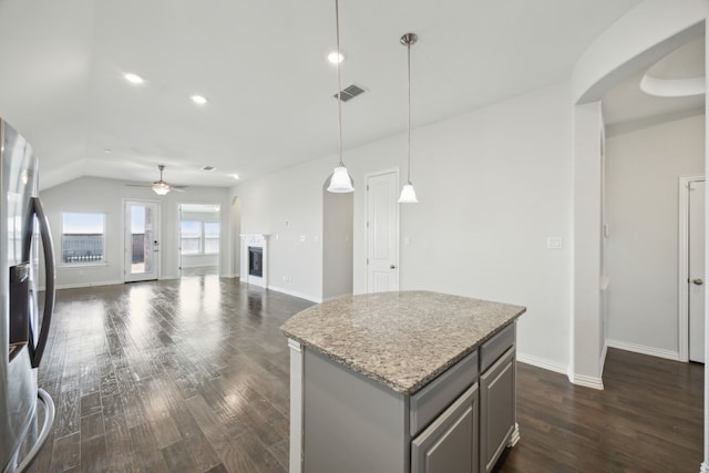 kitchen with a center island, decorative light fixtures, stainless steel fridge, gray cabinets, and ceiling fan