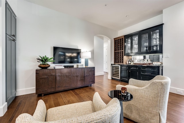 living room featuring beverage cooler, dark wood-type flooring, and indoor bar