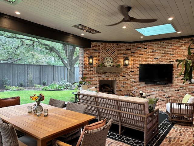 view of patio / terrace featuring ceiling fan and an outdoor living space with a fireplace