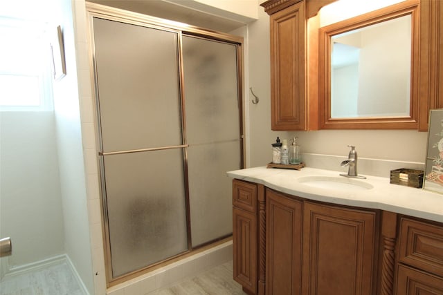 bathroom with a shower with door and vanity