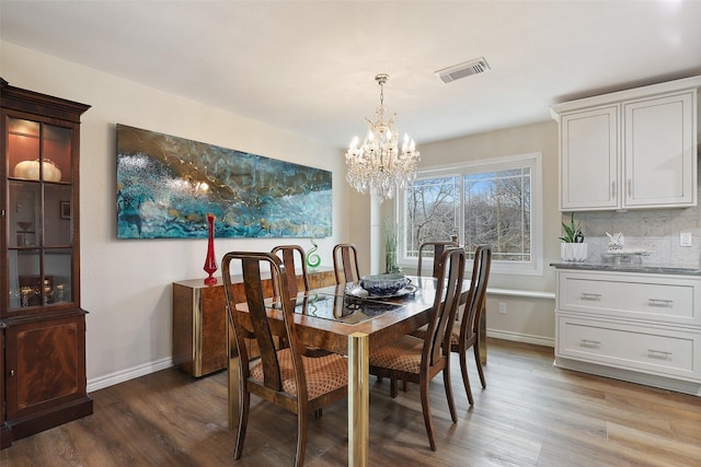 dining area with hardwood / wood-style flooring and a chandelier